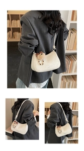 Detail of cream half-moon underarm bag with cute teddy bear charm and beaded strap