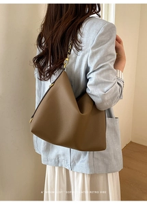 Chic brown litchi pattern leather tote bag with metal chain strap on a female model