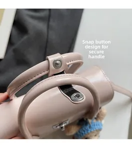 Detail of pink leather handbag showing the snap button handle fastener mechanism