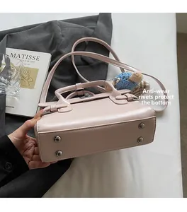 Close-up of the light pink handbag base featuring four silver protective metal rivets