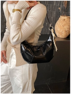 Detail of black crescent moon bag with LOVE & DESIRE text and woven knot charm