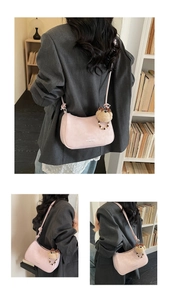 Detail of pink hobo bag with MAIDOU & BAG text and a cute plush bear charm accessory