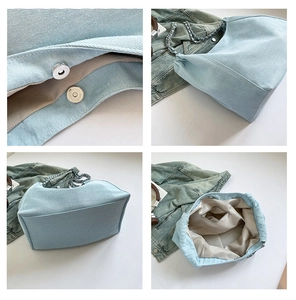 Detail view of denim tote bag showing magnetic buckle, chain strap, and inner zipper pocket