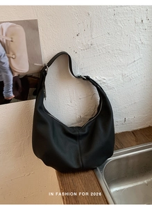 Detail der schwarzen Hobo-Tasche aus genarbtem Leder mit verstellbarem Riemen