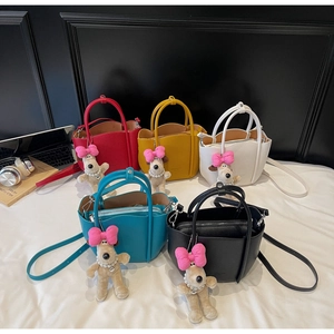 Detail showing five colors of lychee grain leather buckets with cute plush dog charms