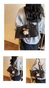 Close-up of a charcoal grey frosted leather tote bag with contrast stitching and teddy charm