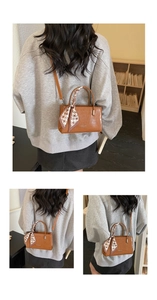 Detailed view of brown crocodile texture handbag with elegant houndstooth silk scarf handle