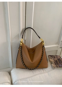 Detailed view of caramel lychee texture and gold metal chain on a retro hobo bag
