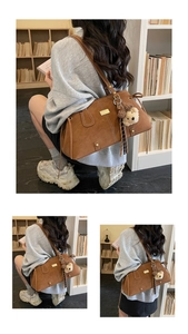 Detail of vintage brown tote bag with white contrast stitching and cute teddy bear charm