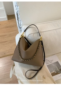 Detail of coffee brown lychee pattern leather tote bag with gold chain and strap