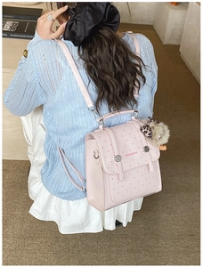 Detail of pink polka dot mini bag with metal buckle and leopard fur charm