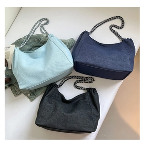 Three colors of denim tote bags with chain straps shown in a lifestyle composition