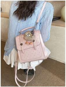Pink polka dot mini backpack shown being worn by a model in a sweet college style