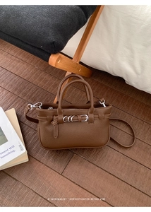 Detail der dunkelbraunen Lederhandtasche mit Silberring und Retro-Hintergrundszene