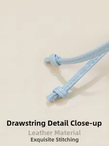 Détail du cordon en cuir bleu clair avec coutures de précision sur un sac seau