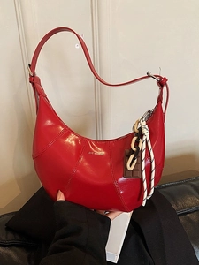 Red glossy crescent shoulder bag with white LOVE & DESIRE text and luxury charms