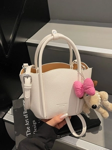 Minimalist beige pebble leather tote bag with cute dog charm and shoulder strap
