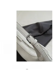 Close-up of white lychee pattern leather shoulder strap with dark gunmetal hardware buckle
