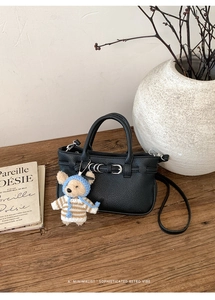 Detail der schwarzen Mini-Tasche mit Litschiprägung, Silberbeschlägen und Bärenanhänger