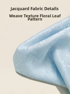 Détail du tissu jacquard bleu clair avec broderie florale et texture tissée