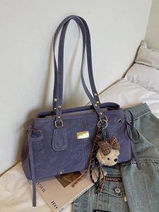 Minimalist purple suede tote bag with golden hardware and plush bear charm decoration