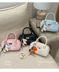 Détail de sacs Boston rayés en quatre couleurs avec breloque cheval et bandoulières