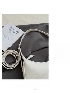 Detail of white lychee pattern leather shoulder bag with adjustable straps and texture