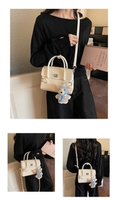 Three-way view of a cream white mini crossbody bag with a plush dog charm on a model