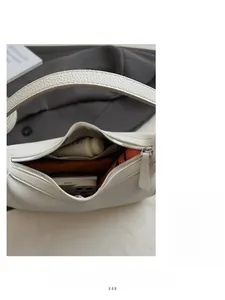 Spacious interior of white lychee leather shoulder bag with essentials and zipper