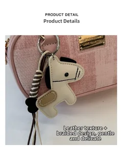 Détail du sac en cuir rose texturé avec breloque poney crème et artisanat de corde tissée
