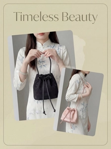 Detail of floral embroidery on drawstring bucket bags in black and soft pink colors