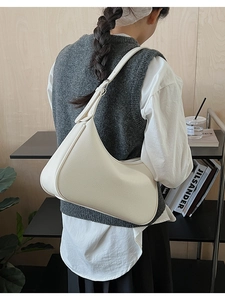 Close-up of cream crescent shoulder bag featuring premium lychee grain leather texture