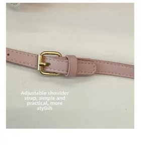 Détail d'une bandoulière réglable en cuir rose pâle avec boucle dorée et coutures fines