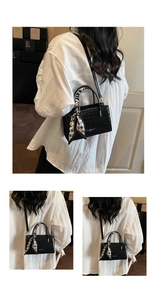 Detail view of black stone pattern handbag with printed silk scarf and crossbody strap