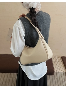 Detailed back view of a beige hobo underarm bag featuring textured lychee grain leather