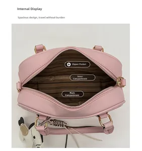 Vue détaillée de l'intérieur du sac Boston rose avec doublure rayée et compartiments