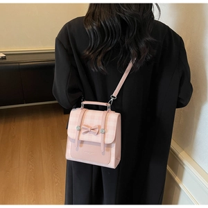 Pink plaid handbag featuring a 3D bow and metal buckles shown on a model