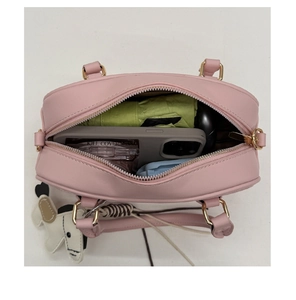 Intérieur du sac à bandoulière en similicuir rose offrant une grande capacité de rangement