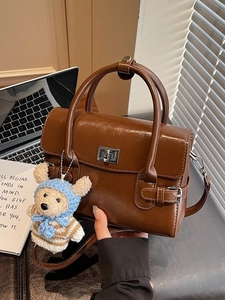 Vintage brown leather crossbody bag with teddy bear pendant and metallic buckle detail