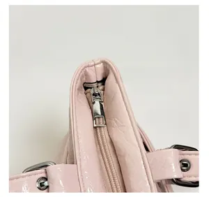 Dettaglio della borsa tote in pelle verniciata rosa con cerniera in metallo