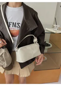 Detail of cream leather shoulder bag featuring knotted strap and silver metal ring