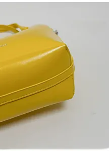 Dettaglio della base rinforzata con cuciture precise di una borsa a secchiello in pelle gialla