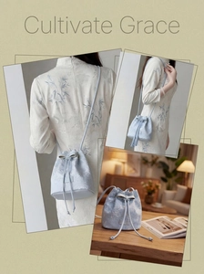 Detail of light blue bucket bag featuring floral embroidery and a decorative bow