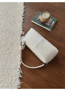 Minimalist beige soft leather underarm bag with knot detail and zipper closure