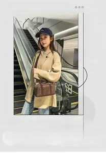 Detail view of dark brown matte PU leather Boston bag shown on a model in urban setting