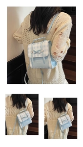 Detail of light blue checkered mini backpack with bow and metal buckle on leather