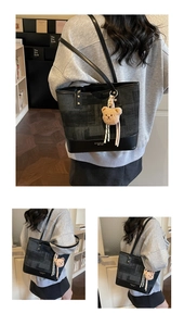 Macro shot of contrast tote bag with leather base, golden logo, and bear charm detail