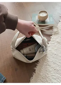 Spacious interior of a cream leather handbag showing capacity for cosmetics and accessories