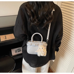 Mini borsa tote grigio chiaro con ciondolo a coniglio indossata a tracolla da una modella
