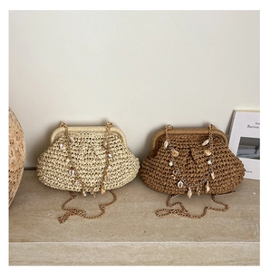 Detail of hand-woven straw bags with shell charms and gold chains on a stone surface